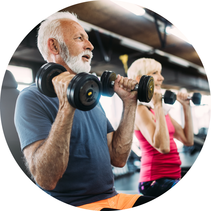 A senior man with his partner in a weights-based group fitness class